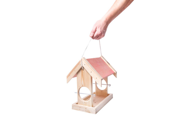Wooden bird feeder for feeding birds in winter season in man hand - 写真・画像