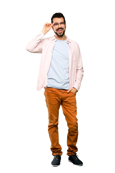 Full-length shot of Handsome man with beard with glasses and surprised over isolated white background - Photo, Image