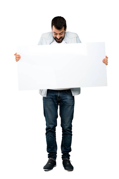 Full-length shot of Handsome man with beard holding an empty placard over isolated white background - Fotografie, Obrázek