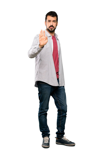 Full-length záběr pohledný muž s vousy dělat stop gesto přes izolované bílé pozadí - Fotografie, Obrázek