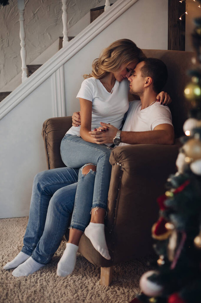 Loving couple sorting presents by Christmas tree. - Photo, Image