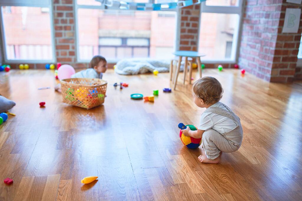 Beautiful toddlers playing around lots of toys at kindergarten - Photo, Image