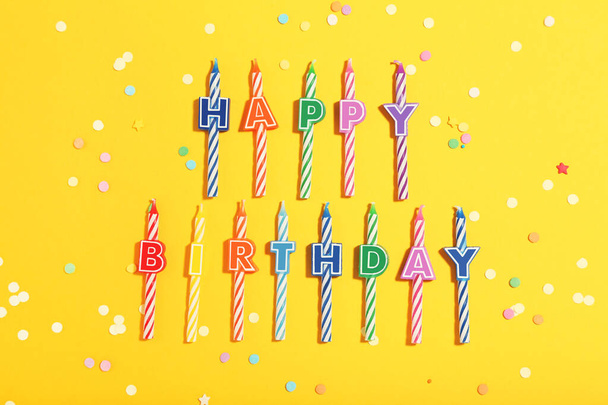 Candles with text Happy Birthday on yellow background. Minimalis - 写真・画像