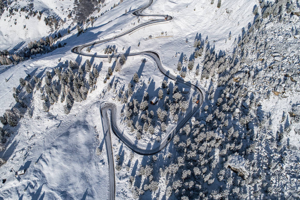 Curved road in the Italian Alps in South Tyrol, during winter / Sunny winter day with harsh shadows and lot of snow - Fotografie, Obrázek