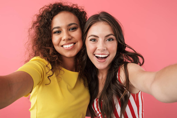 Image of amazing multinational girls smiling at camera while taking selfie photo - Фото, зображення