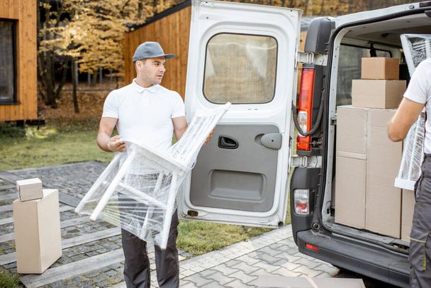 Delivery company employees unloading cargo van vehicle - 写真・画像