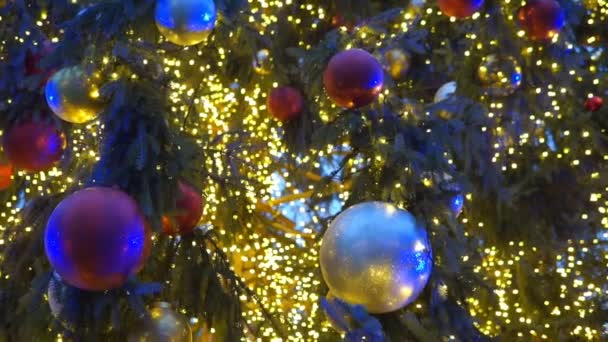Geceleri parlayan bir Noel ağacı ışığını kapat. Süslemeleri ve aydınlatması olan yeni yıl ağacı. Xmas ağaç dekorasyonu arkaplanı. - Video, Çekim