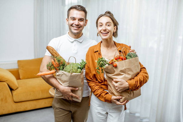 Young couple with groceries at home - Photo, Image