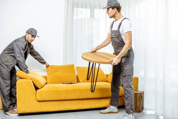 Movers placing furniture at home - Foto, afbeelding