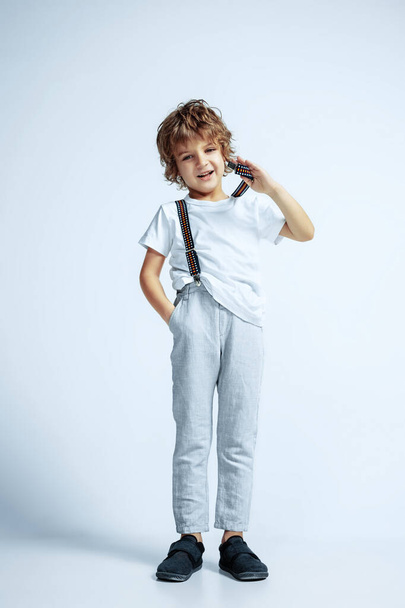 Pretty young boy in casual clothes on white studio background - 写真・画像