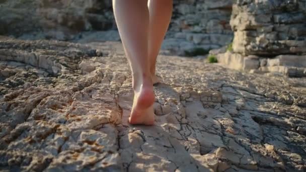 mulher está andando sobre rochas no verão, close up de pernas
 - Filmagem, Vídeo