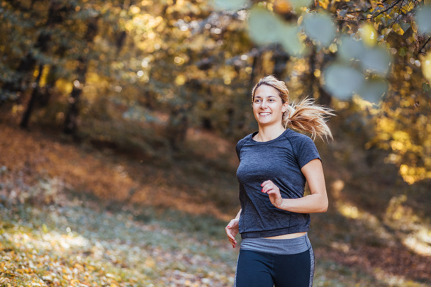 Осенью в лесу бегает молодая спортсменка
 - Фото, изображение