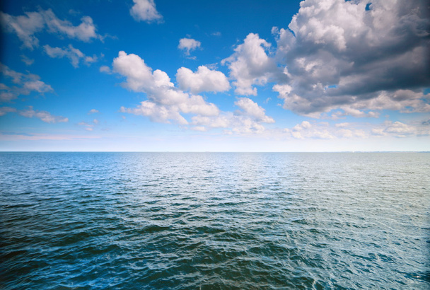 Σύννεφο γαλάζιο ουρανό πάνω από μια επιφάνεια της θάλασσας - Φωτογραφία, εικόνα