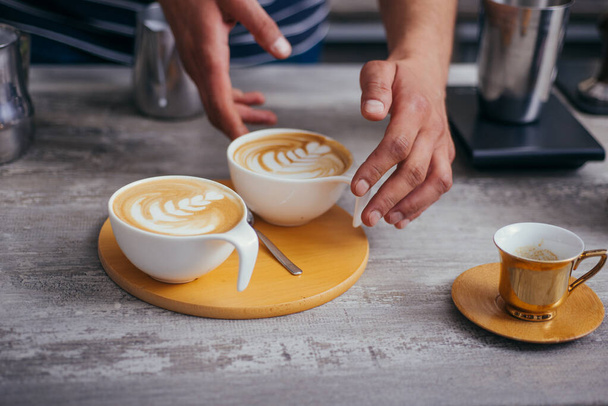 Cups of art latte on a cappuccino coffee on table - Фото, зображення
