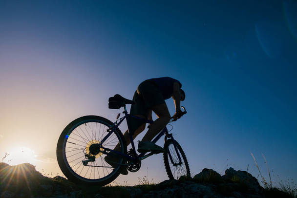Silhueta de um ciclista de montanha andando de bicicleta esportiva de montanha em
  - Foto, Imagem