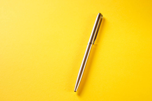 metal pen isolated on yellow background - Fotoğraf, Görsel