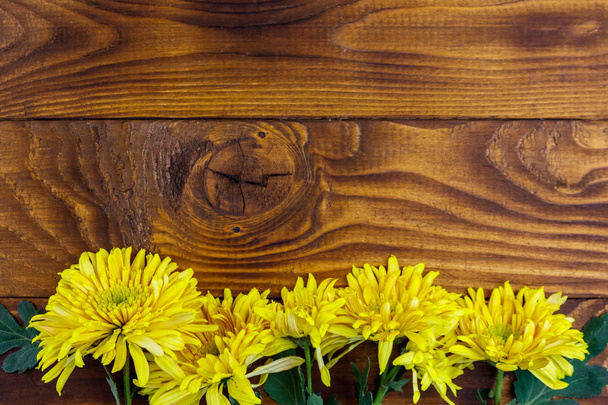Yellow chrysanthemums on wooden background. Top view, copy space - Foto, Bild