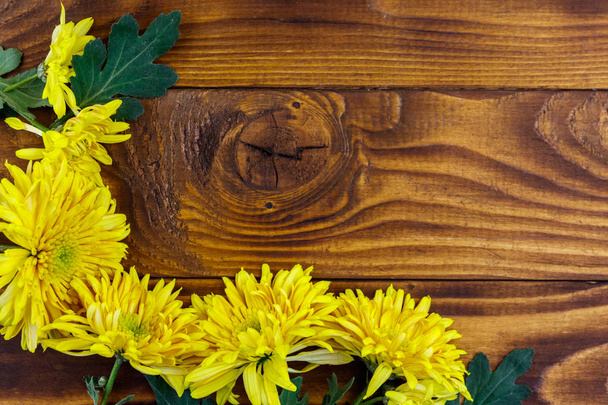Chrysanthèmes jaunes sur fond en bois. Vue du dessus, espace de copie - Photo, image