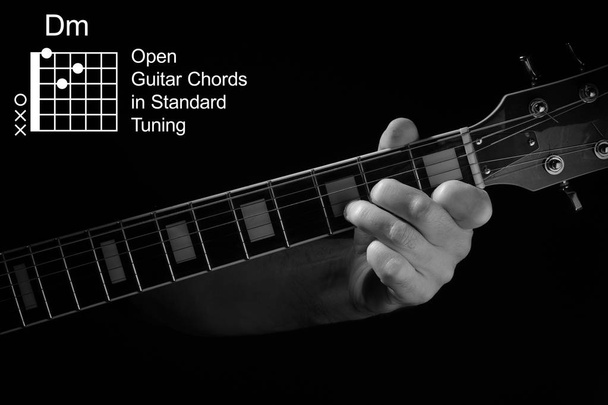 Open Guitar akordy ve standardní ladění kytarové tutoriál série. Detailní záběr z ruky hraje Dm akord na kytaru, na černém pozadí. Černobílá fotografie. - Fotografie, Obrázek
