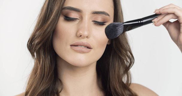 Young Beauty Gently Using a Makeup Brush - Photo, Image
