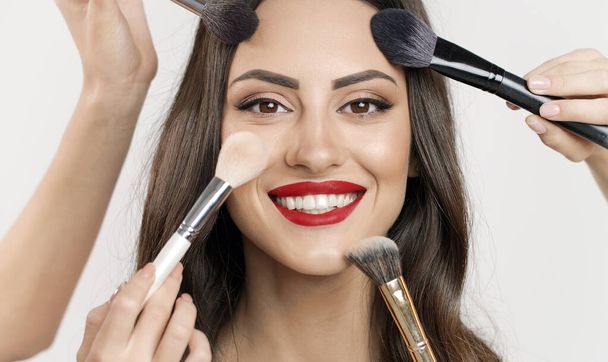 Multiple Makeup Brushes Touching Young Womans Face - Valokuva, kuva