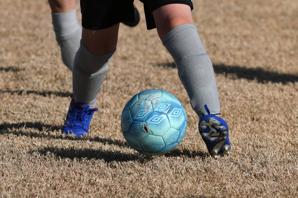 Αγόρια τρέχουν και κλωτσάνε μπάλα ποδοσφαίρου. Κοντινό πλάνο δράσης ομάδων ποδοσφαίρου αγοριών, ηλικίας 8-10 ετών, που παίζουν ποδόσφαιρο στο γήπεδο. - Φωτογραφία, εικόνα