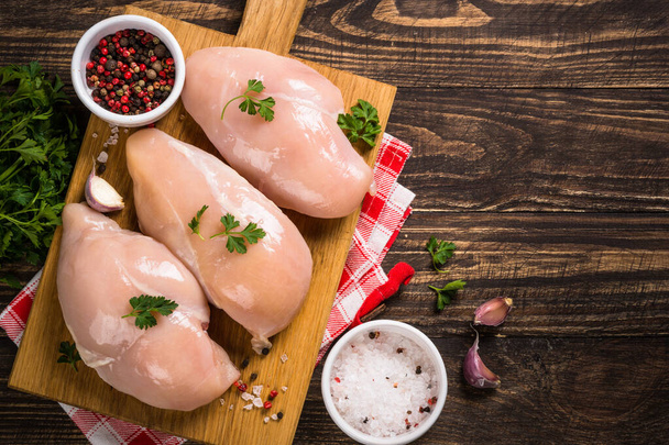 Филе курицы с ингредиентами для приготовления пищи на деревянном столе. - Фото, изображение