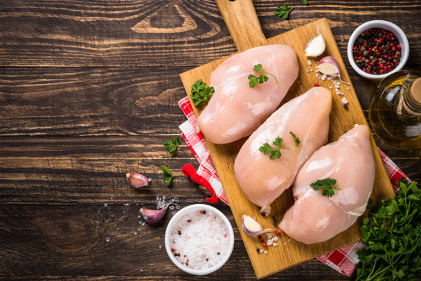Hühnerfilet mit Zutaten zum Kochen auf Holztisch. - Foto, Bild