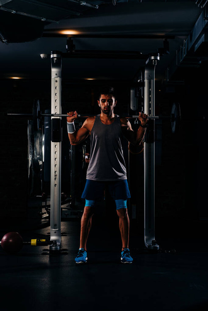 Karcsú izmos férfi edz súlyokkal a tornateremben - Fotó, kép