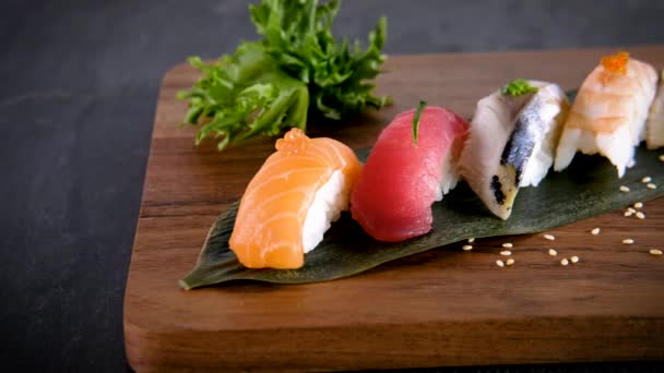 Vari sashimi nigiri decorati serviti su tavola di legno. Sushi con salmone, tonno, sgombro, gambero e anguilla. Menù ristorante giapponese. Chiudi, fai scorrere il movimento. 4K
 - Filmati, video