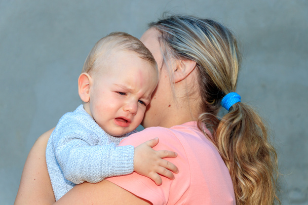 Retrato de un bebé llorando. El niño llora en el abrazo de su madre. Emoción, amor
 - Foto, Imagen