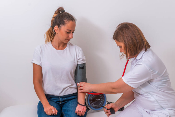 Női orvos méri a vérnyomását a fiatal tini pat - Fotó, kép