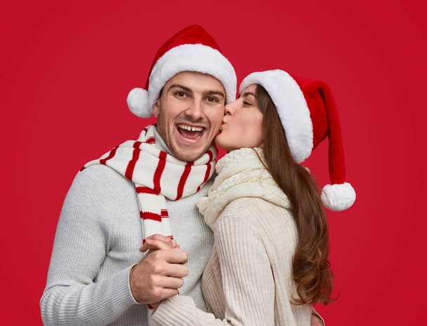 Woman kissing boyfriend during Christmas party - Zdjęcie, obraz