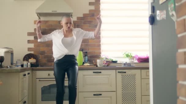 medium shot. young amazingly emotional bald woman dancing in the kitchen at home - Filmagem, Vídeo