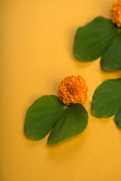 Indian Festival Dussehra, showing golden leaf (Bauhinia racemosa) and marigold flowers on a yellow background. - 写真・画像