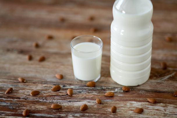 milk and almonds on wooden table - Fotografie, Obrázek