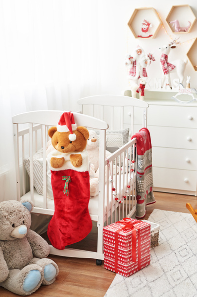 Christmas nursery, Christmas decor in children's bedroom, children's playroom decorated for new year, white children's bedroom, Christmas toys and gifts in children's bedroom, white bed with soft toys - Photo, Image