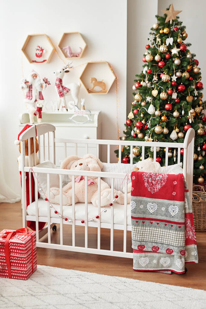 Joulun lastentarha, joulun sisustus lasten makuuhuoneessa, lasten leikkihuone sisustettu uusi vuosi, valkoinen lasten makuuhuone, joulun lelut ja lahjat lasten makuuhuoneessa, valkoinen sänky pehmeillä leluilla
 - Valokuva, kuva