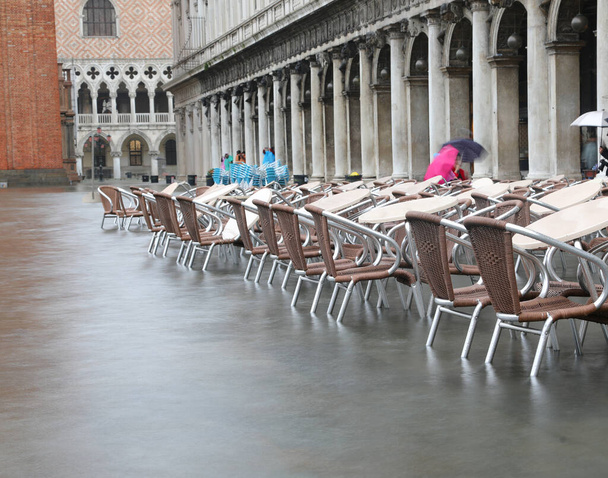 Chairs and tables of alfresco cafe in Saint Mark square during t - Photo, Image