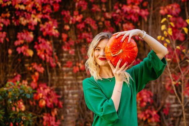 Portrait of woman having fun with pumpkin - Photo, Image