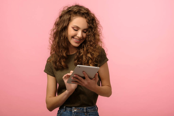Pretty girl with tablet on pink background - Фото, зображення