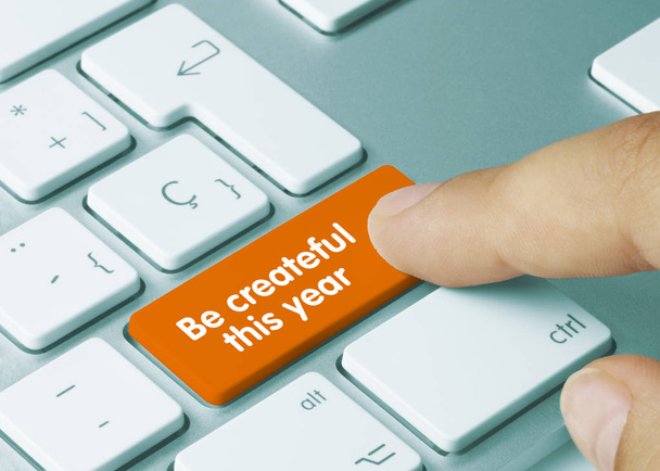 Be createful this year  - Inscription on Orange Keyboard Key. Be createful this year  Written on Orange Key of Metallic Keyboard. Finger pressing key - 写真・画像