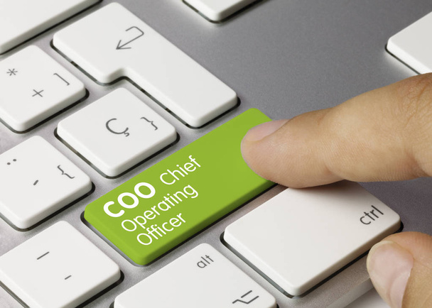 Coo Chief Operating Officer - napis na zielonym klawiszu klawiatury. Dyrektor operacyjny Coo napisany na zielonym klawiszu metalowej klawiatury. Naciśnięcie klawisza palca. - Zdjęcie, obraz