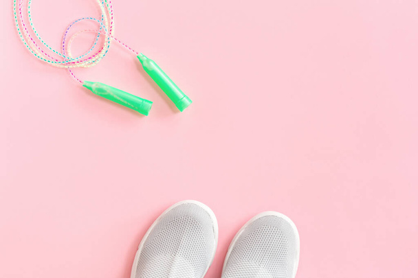 Textile sport shoes with jumping skipping rope on pink - Φωτογραφία, εικόνα