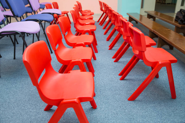 turma de jardim de infância com as cadeiras vermelhas das crianças. Cadeiras vermelhas em Montessori Jardim de infância Sala de aula pré-escolar
 . - Foto, Imagem