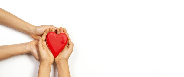 A kezek vörös szívet tartanak a fehér háttér felett. Szerelem, egészségügy, család, biztosítás, adomány koncepció - Fotó, kép