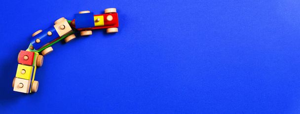 青の背景にカラフルなブロックと木のおもちゃの列車。トップ ビュー - 写真・画像