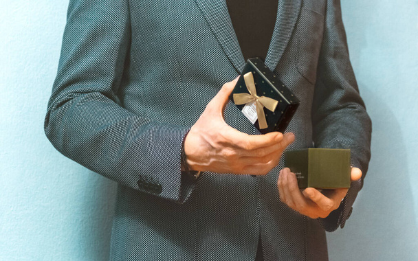 Close view of man in grey suit opening gift box  - Foto, Imagem