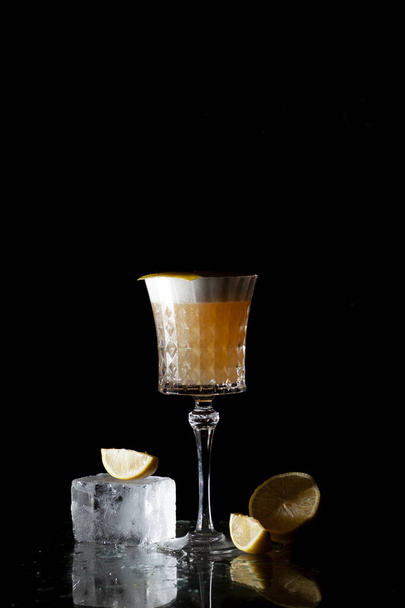 classic amber cocktail with citrus and ice on a black background - Photo, Image