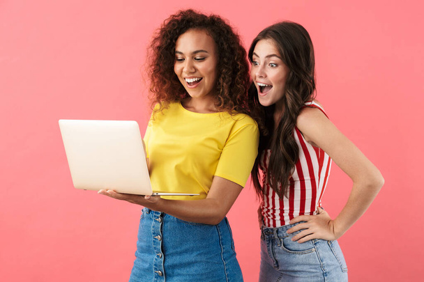 Image of delighted multinational girls rejoicing and holding laptop computer - Foto, immagini